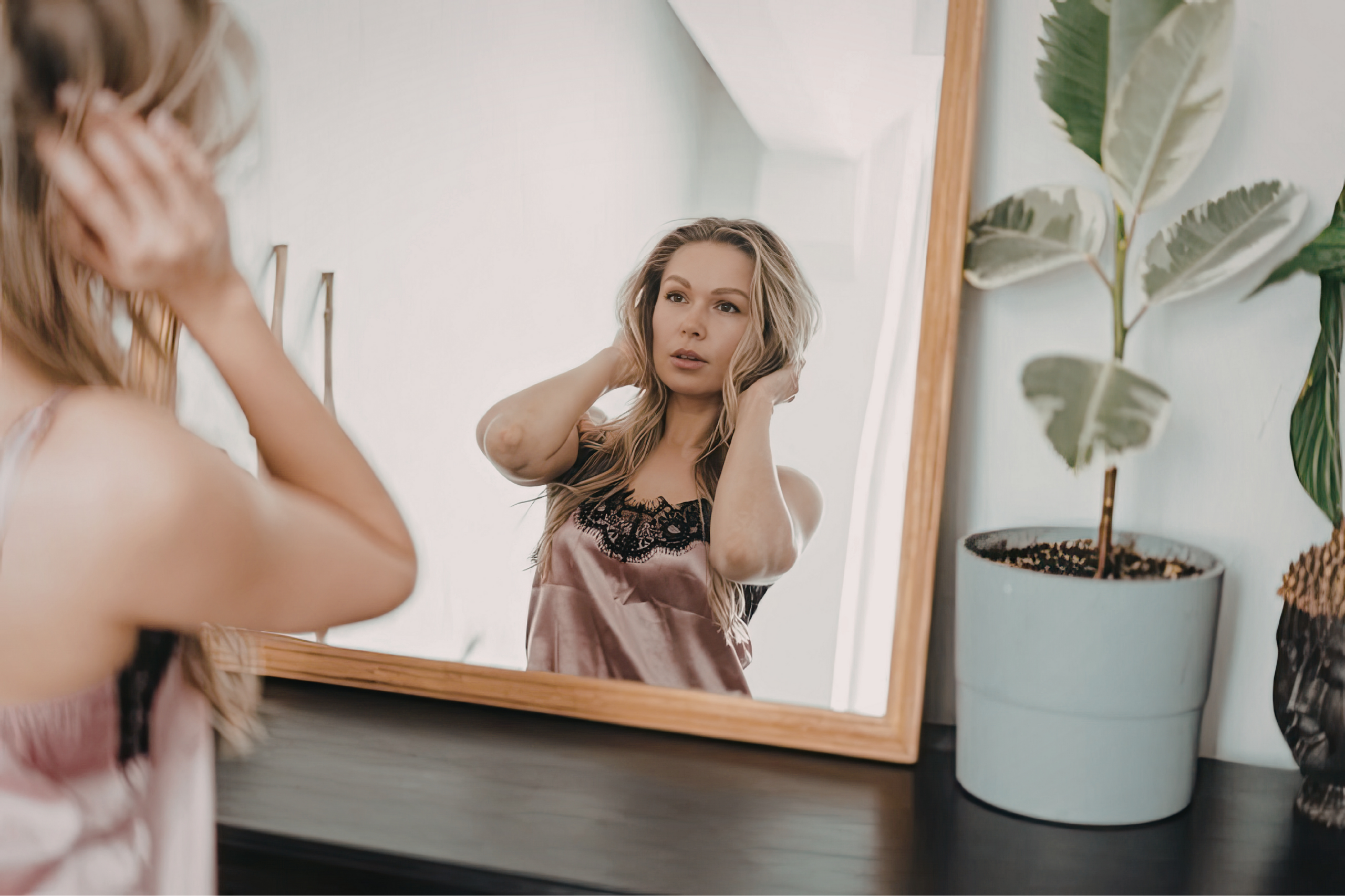 Woman looking in mirror noticing changes in her skin from stress in Omaha